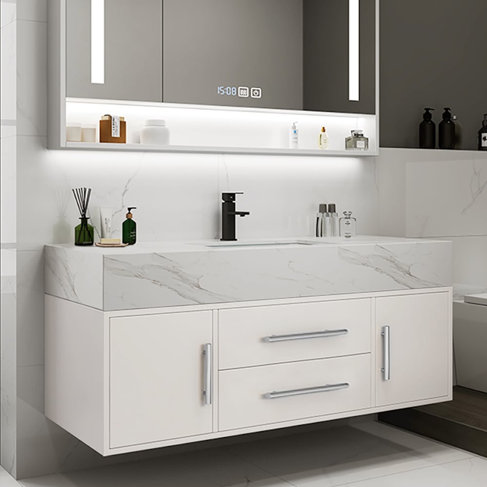 Bathroom vanity with white countertop, cabinets, and mirror with digital clock.
