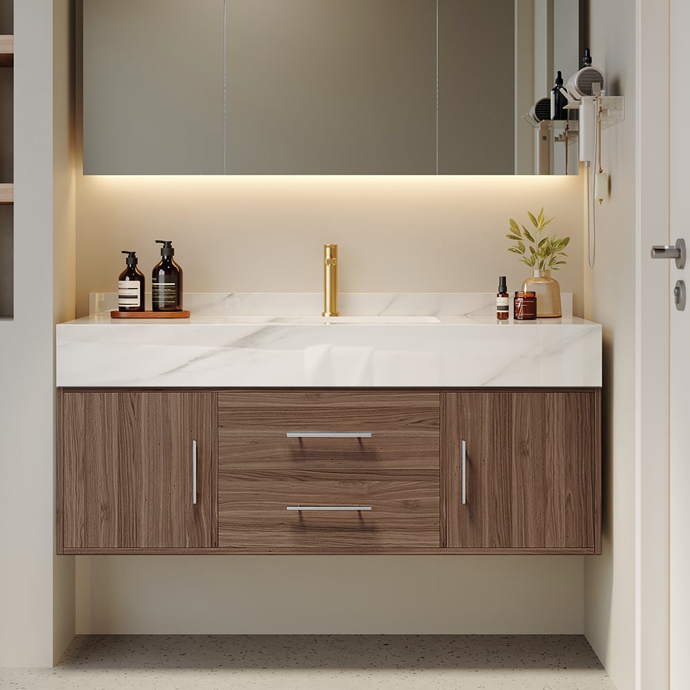 Bathroom vanity with wooden cabinets, white countertop, and gold faucet.
