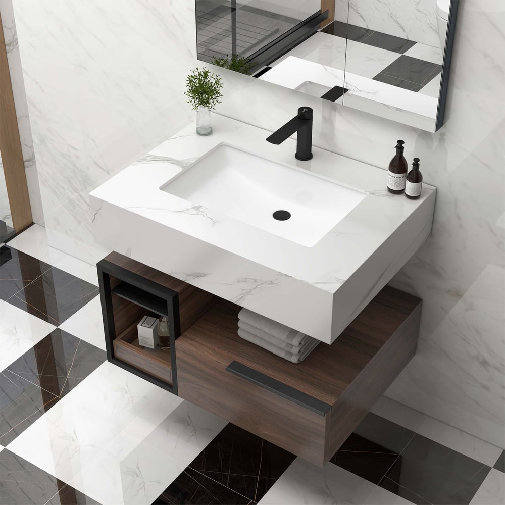 Bathroom vanity with white sink and wooden cabinet against a marble wall.