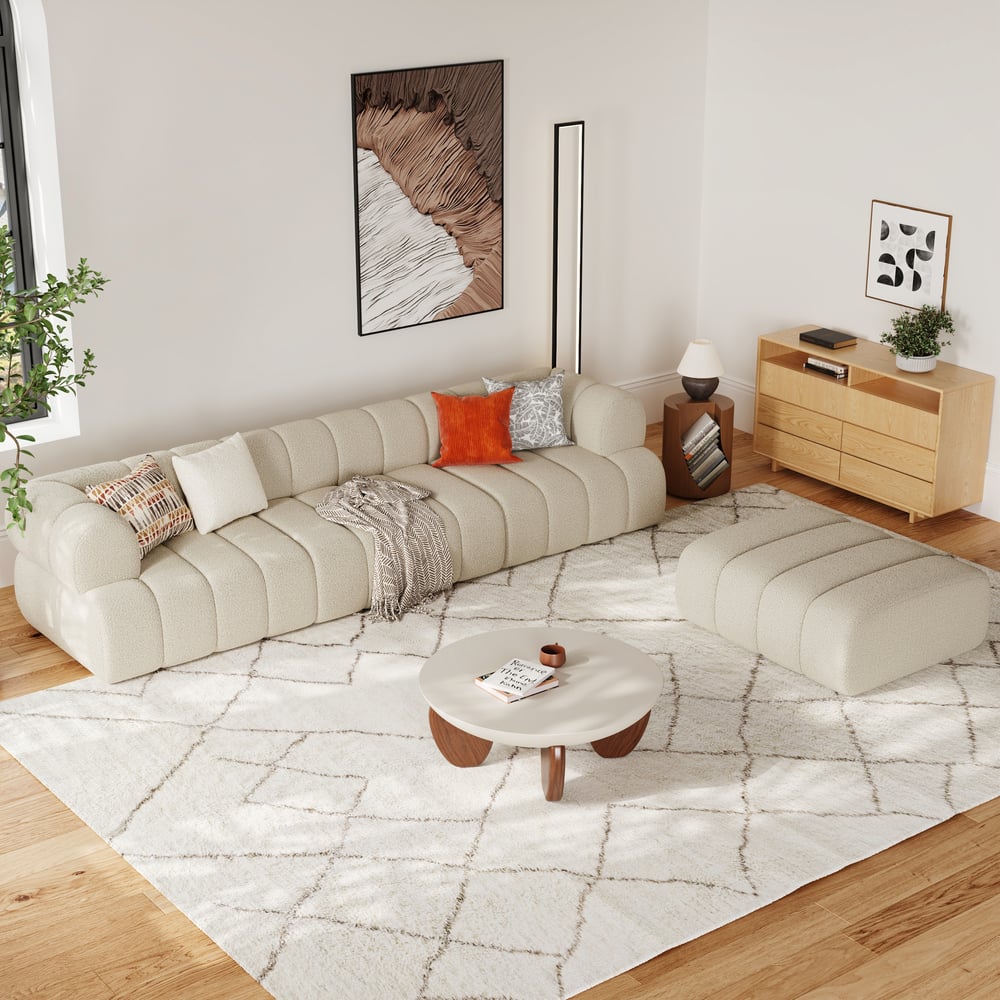 Modern living room with a beige sectional sofa, coffee table, and decorative items.