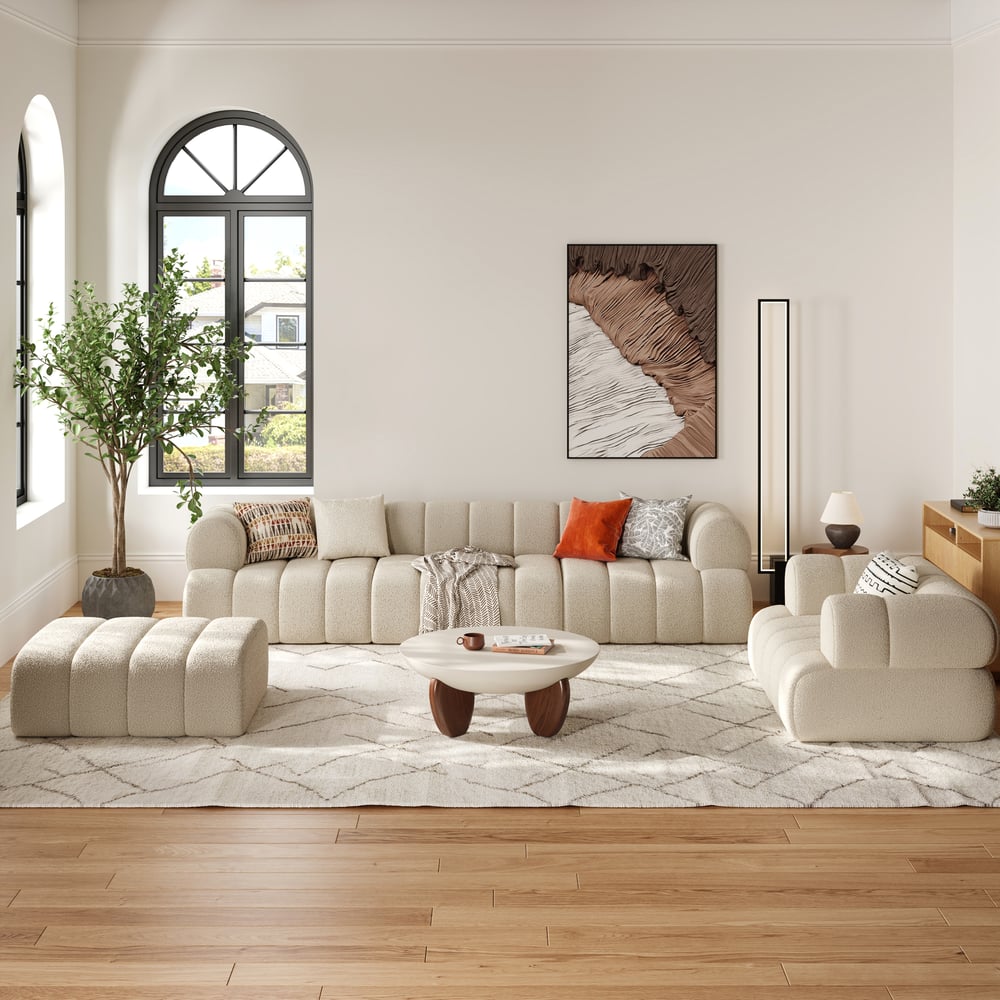 Modern living room with beige sofa, ottoman, and coffee table.