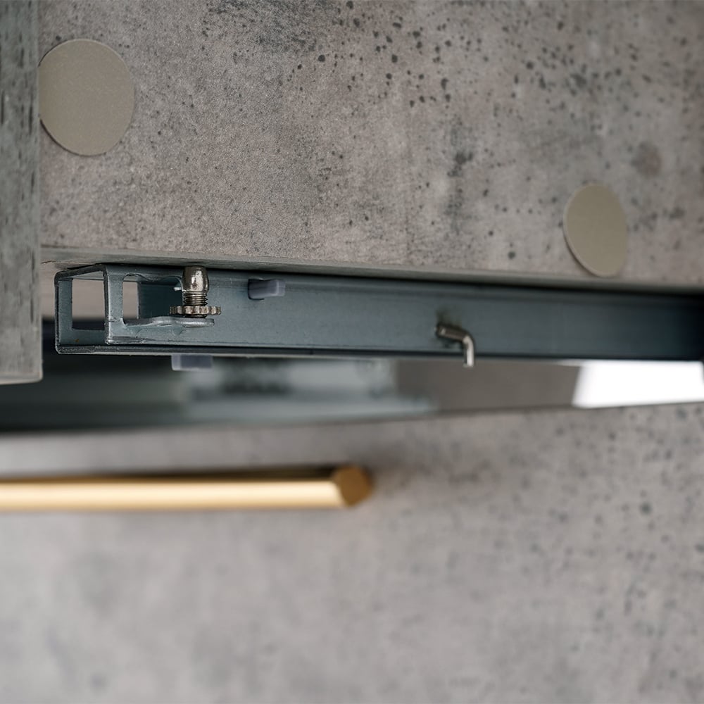 Close-up of a kitchen cabinet with a gold handle on a concrete surface