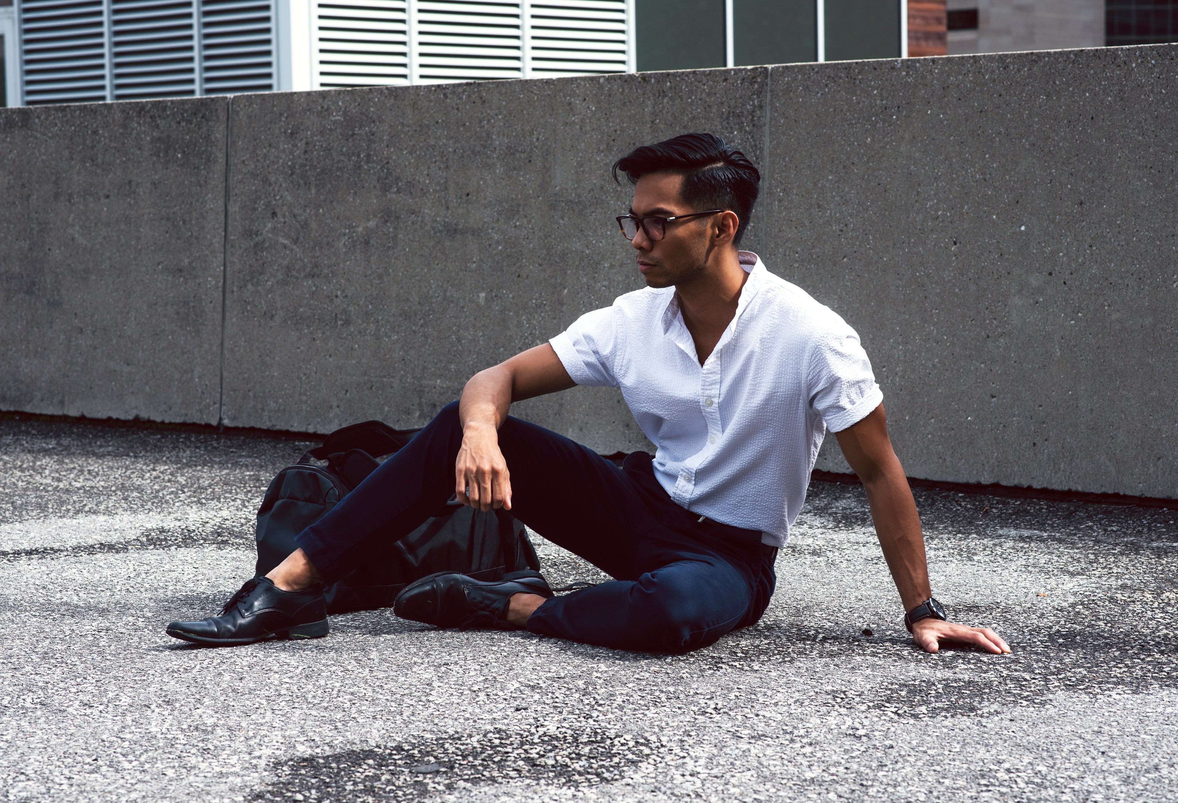 An handsome man sitting on a rooftop