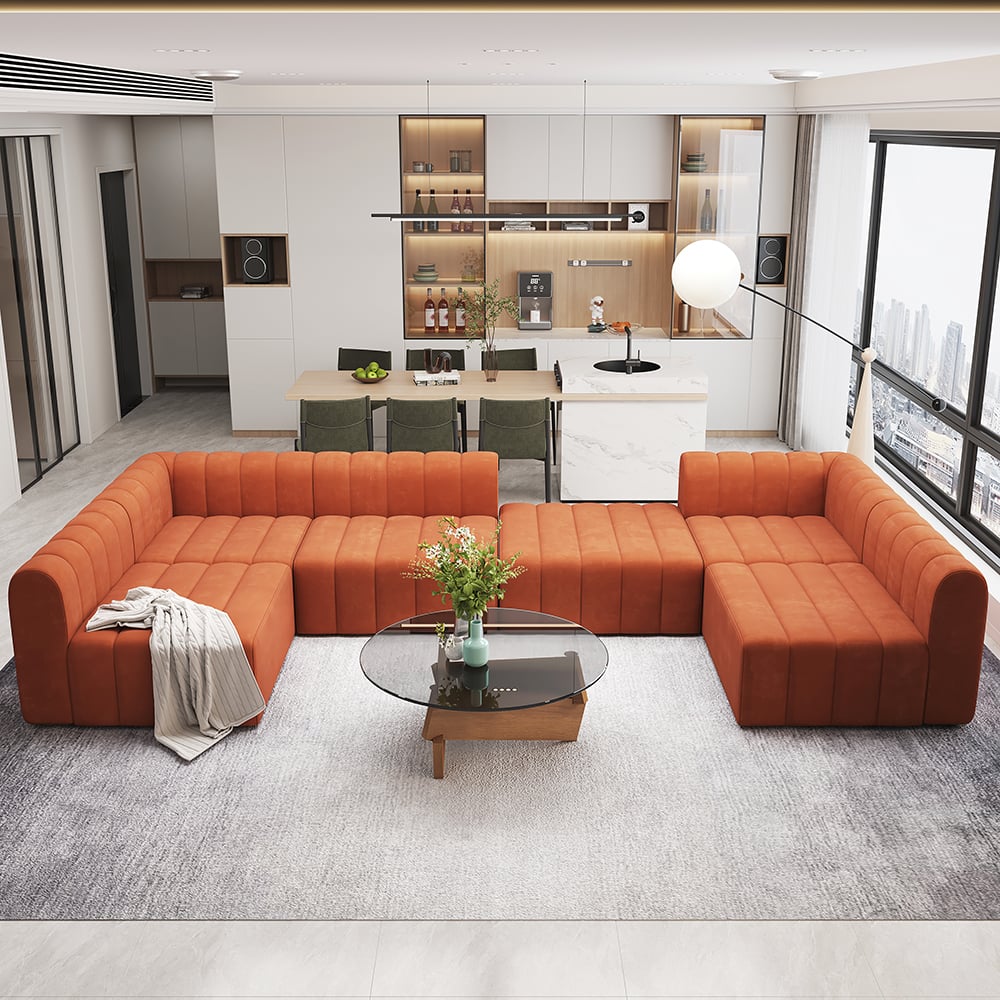 Modern living room with orange sectional sofa and kitchen in the background