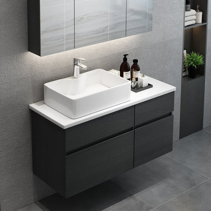 Bathroom vanity with white sink and dark wood cabinets against a gray wall.