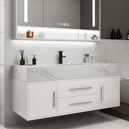 Bathroom vanity with white countertop, cabinets, and mirror with digital clock.
