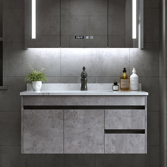 Bathroom vanity with marble countertop and decorative items against a tiled wall.