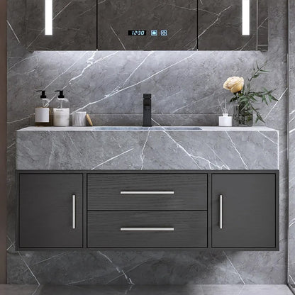 Bathroom vanity with gray marble countertop and dark cabinets.