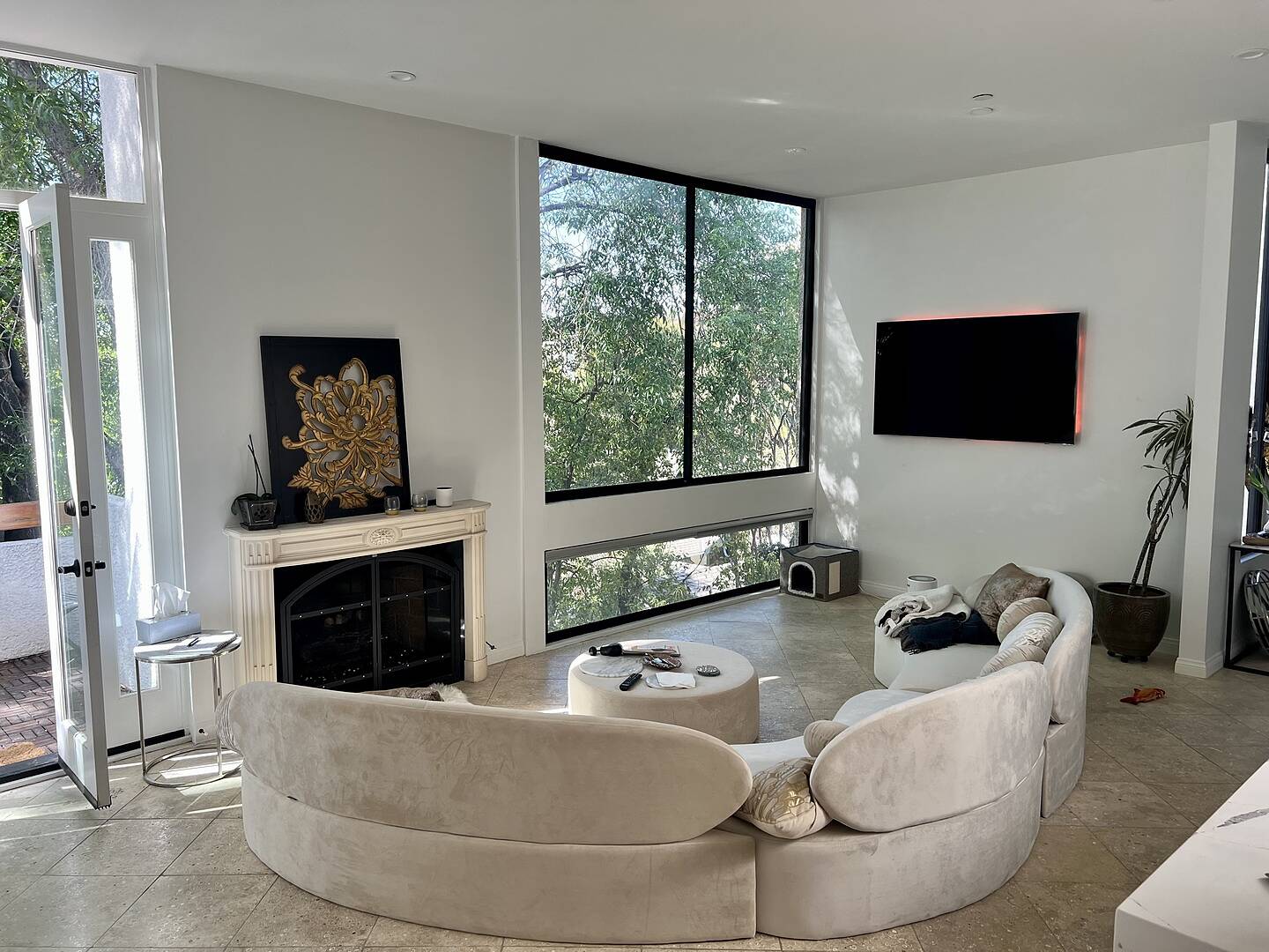 Modern living room with a large curved sofa, coffee table, and wall-mounted TV.