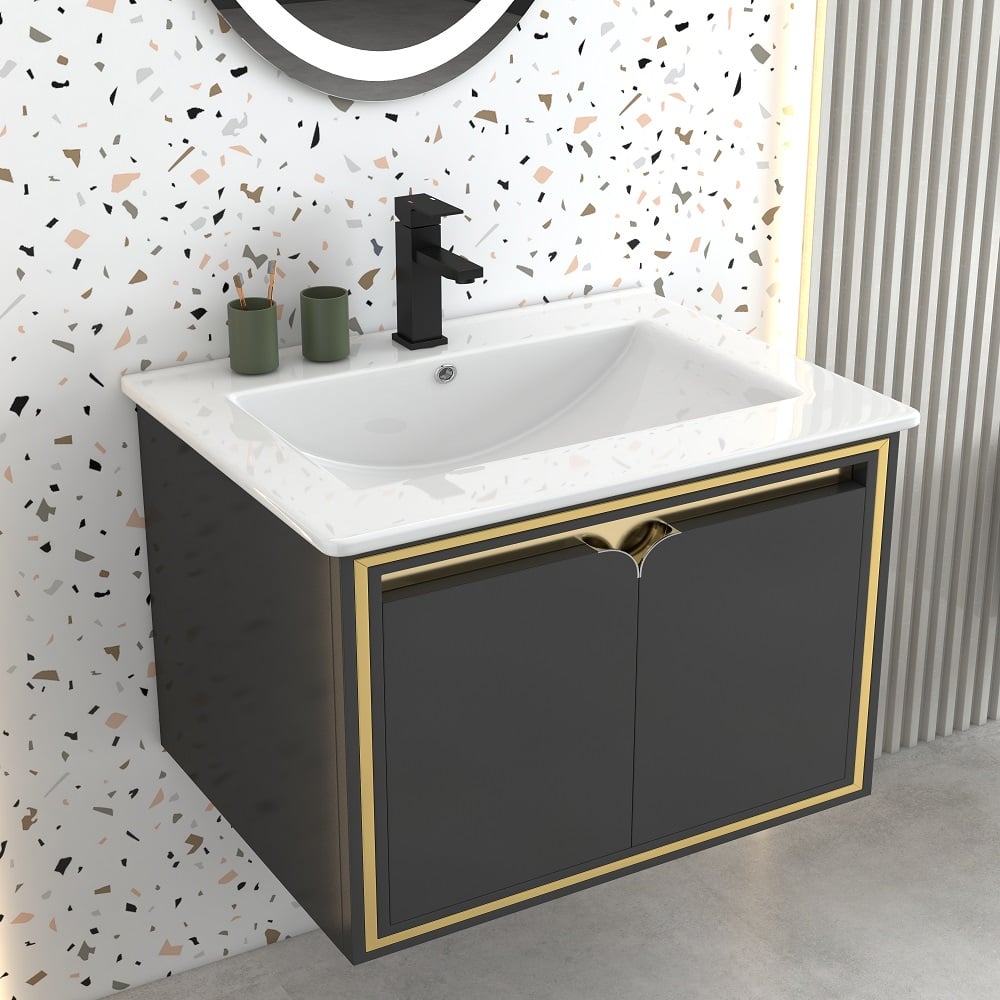 Bathroom vanity with white sink, black faucet, and gold trim against a terrazzo wall.