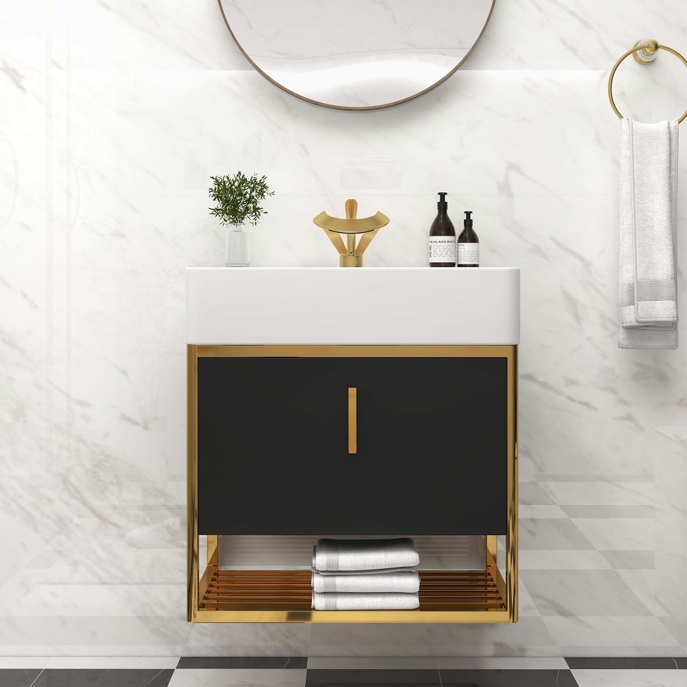 Bathroom vanity with black cabinet and gold frame, featuring a mirror and decorative items.