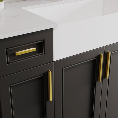 Gray kitchen cabinets with gold handles on a white countertop.