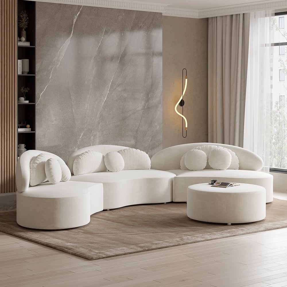 Modern living room with a white sectional sofa, round ottoman, and marble accent wall.