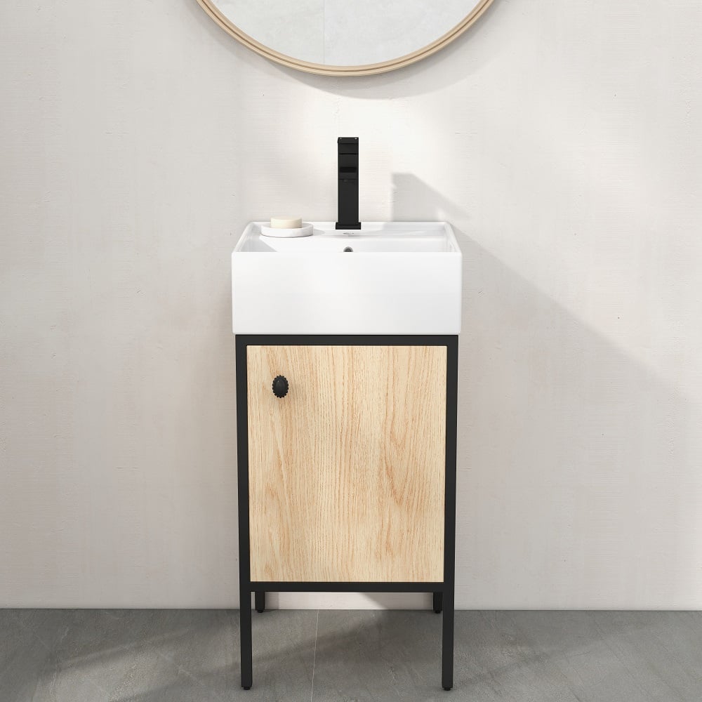 Bathroom vanity with wooden cabinet and white sink against a plain wall.