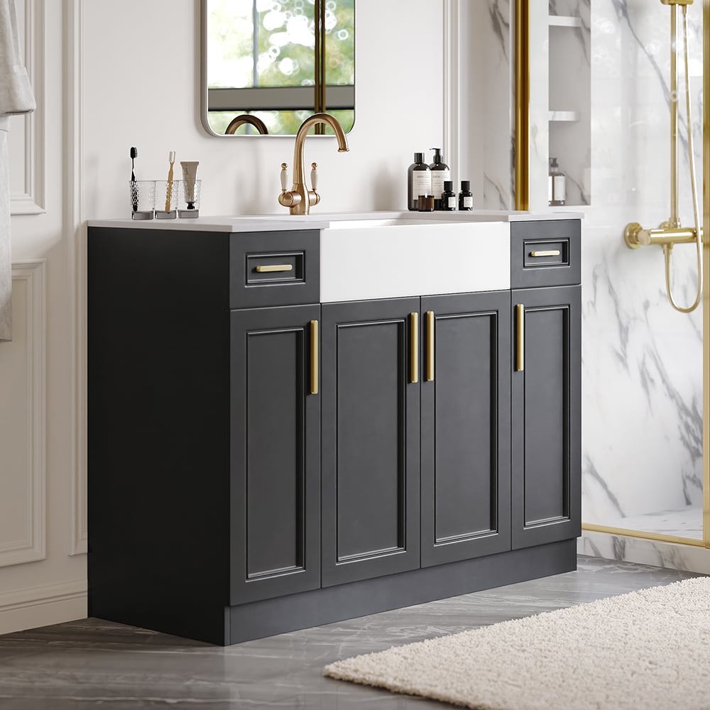 Bathroom vanity with dark gray cabinets, white countertop, and gold fixtures.