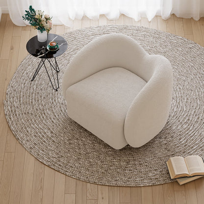 Round beige rug on a wooden floor with a modern chair and small table.