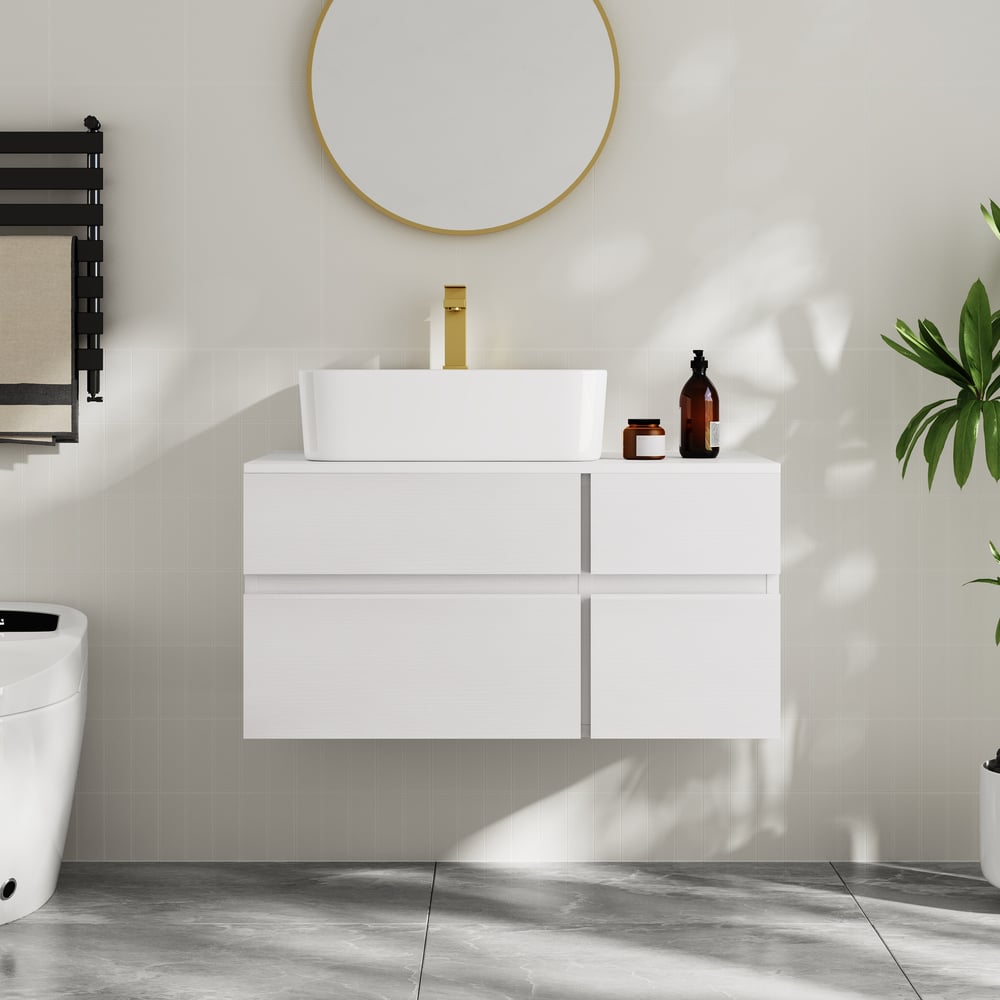 Bathroom setup with a white vanity unit, sink, and decorative items on a light gray wall.