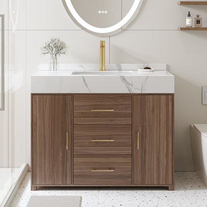 Bathroom vanity with wooden cabinet, marble countertop, and round mirror with light.
