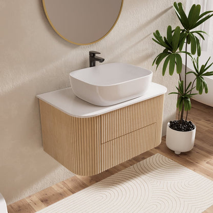 Bathroom vanity with white sink, wooden cabinet, and plant on a wooden floor.