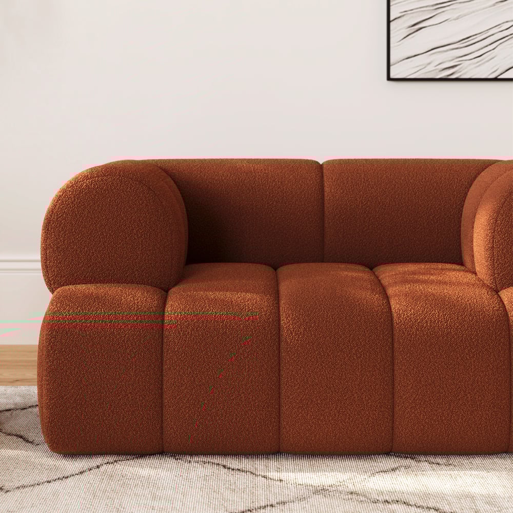 Brown sofa in a room with a light-colored wall and a framed picture.
