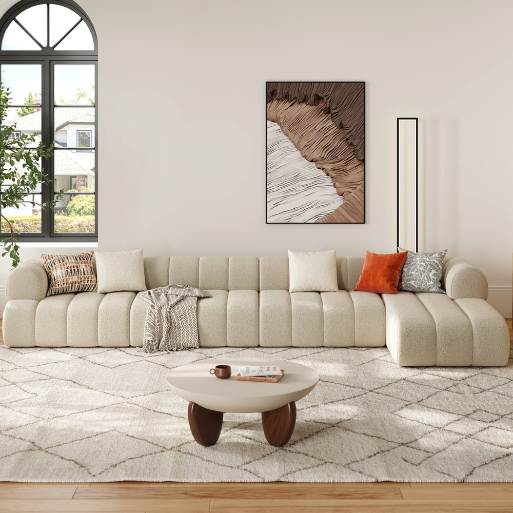 Modern living room with a beige sectional sofa, coffee table, and decorative elements.