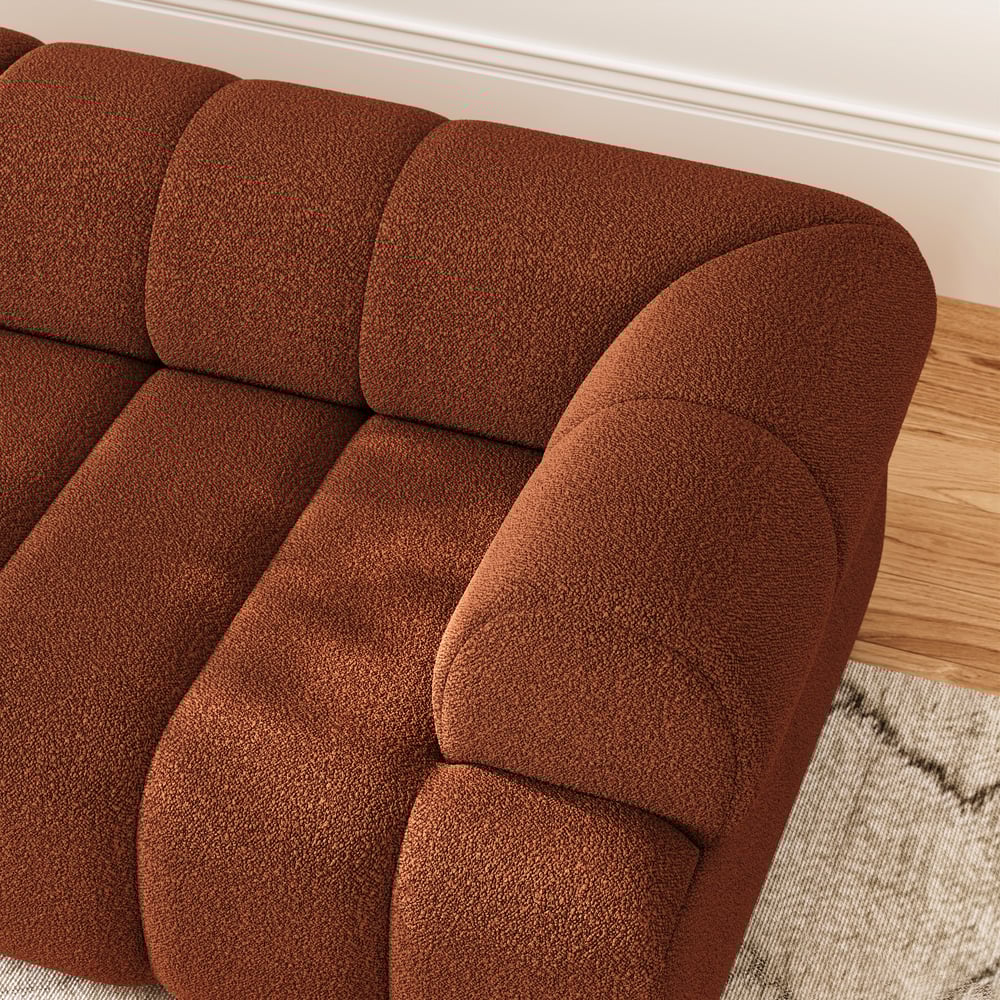Brown textured sofa in a room with wooden flooring.