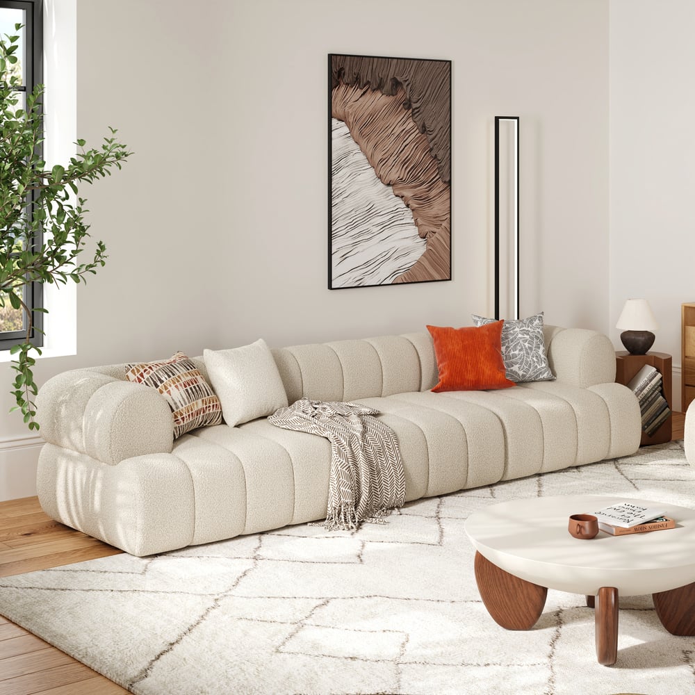 Modern living room with a beige sectional sofa, decorative pillows, and a coffee table.