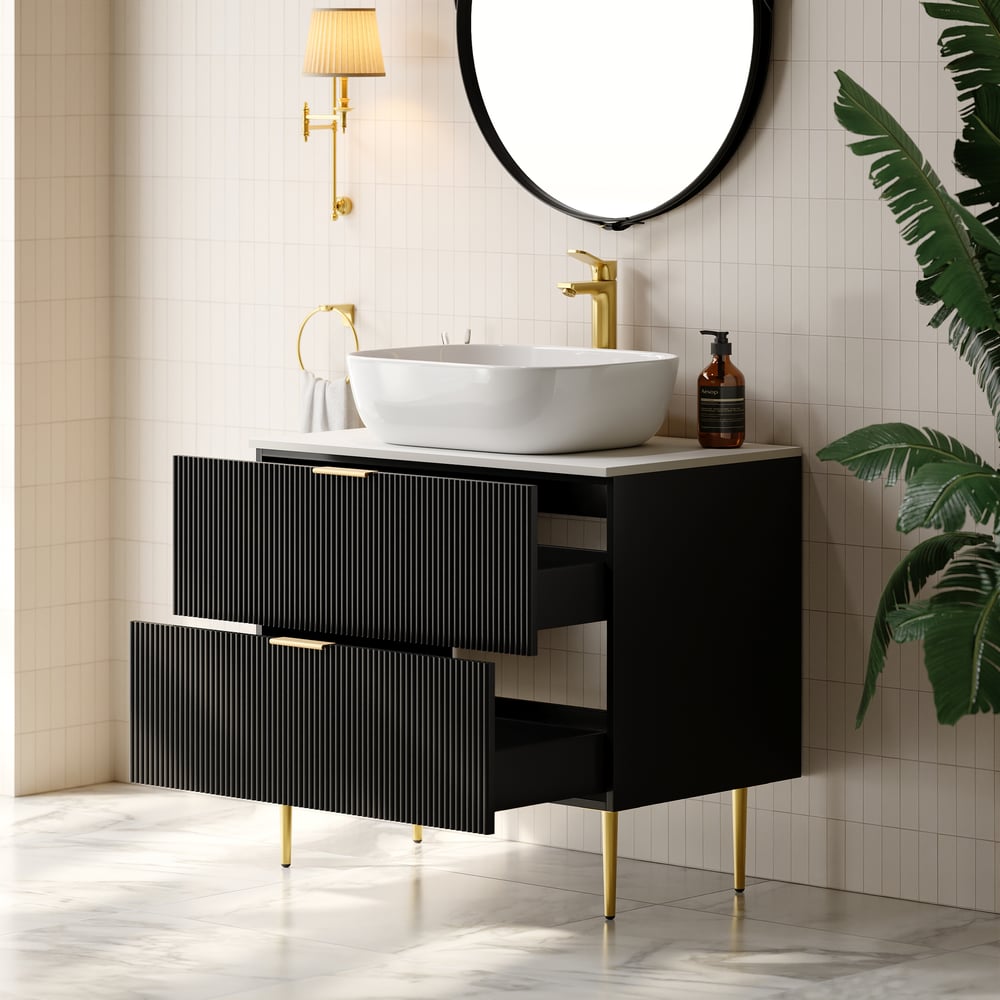 Bathroom vanity with black cabinet, white sink, and gold fixtures.