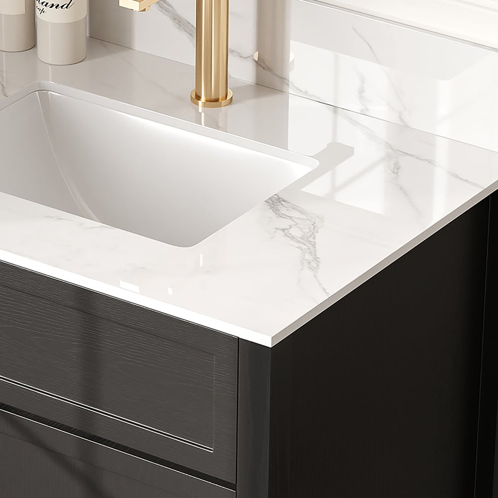 Bathroom vanity with white countertop, black cabinet, and gold faucet.