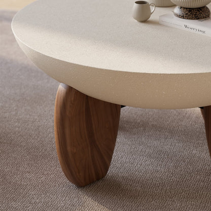 Coffee table with a textured surface and wooden legs on a carpeted floor