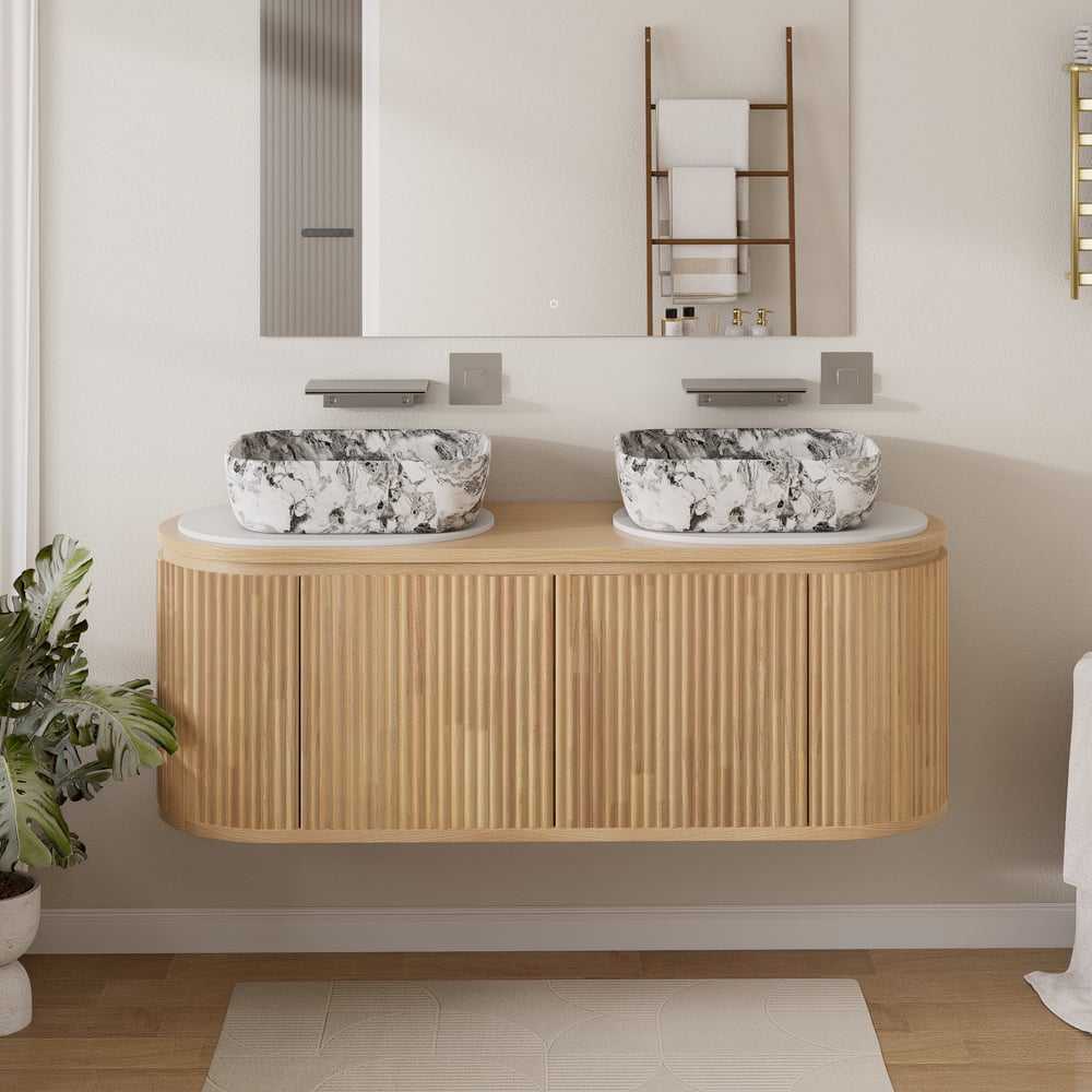 Bathroom vanity with two marble sinks and a mirror above, featuring a plant on the left.