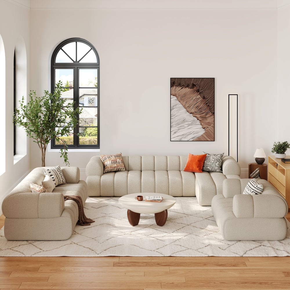 Modern living room with beige sectional sofa, coffee table, and decorative pillows.