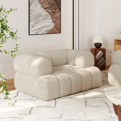 Beige armchair in a modern living room with a plant and framed artwork.