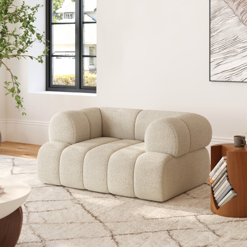 Beige sofa in a modern living room with a plant and coffee table.