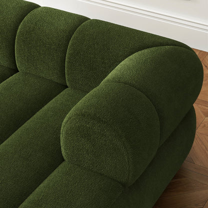 Green upholstered chair on a wooden floor with white baseboard.