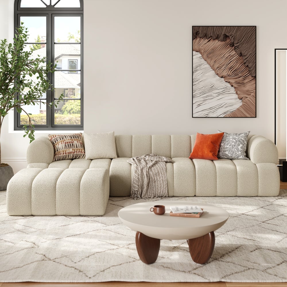 Modern living room with a beige sofa, coffee table, and decorative wall art.