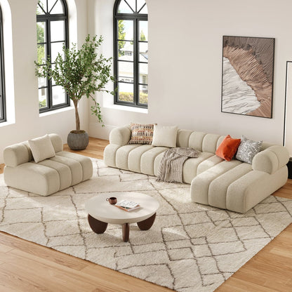 Modern living room with beige sofa, armchair, and coffee table on a patterned rug.