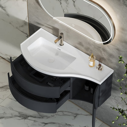 Bathroom vanity with white sink and black cabinet against a marble wall.