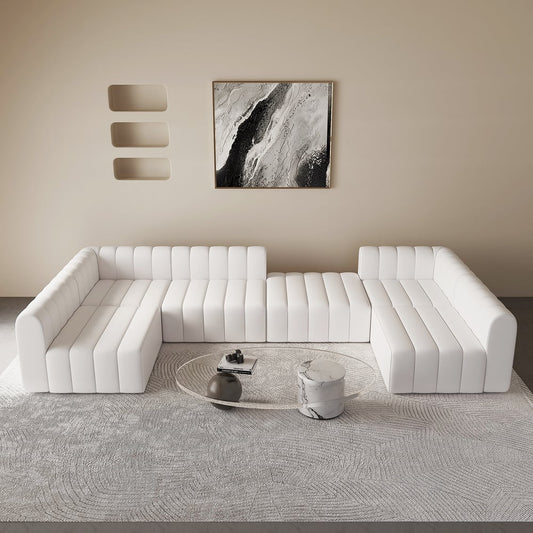 Modern white sectional sofa in a minimalistic living room with abstract art on the wall.