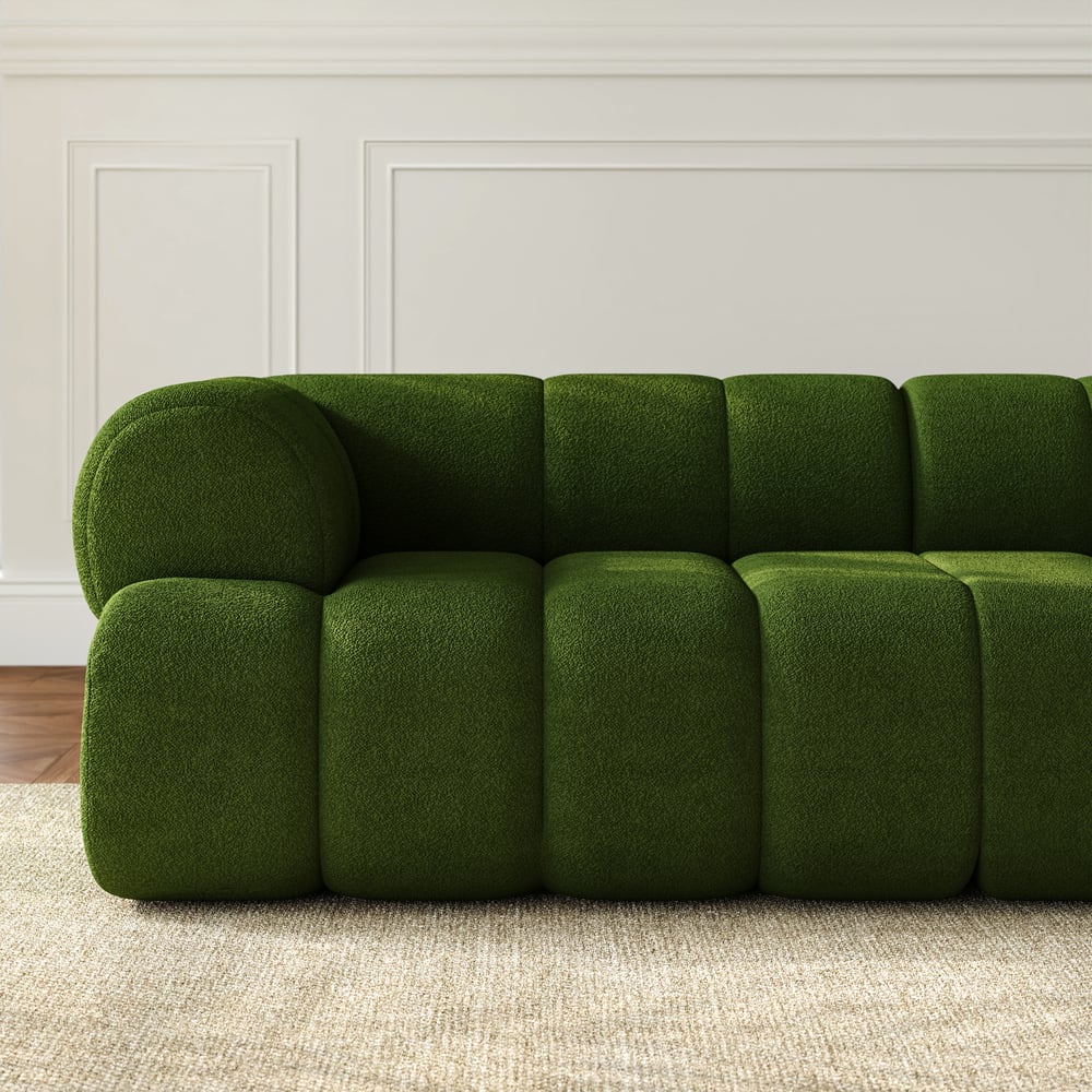 Green sofa in a room with white walls and wooden flooring