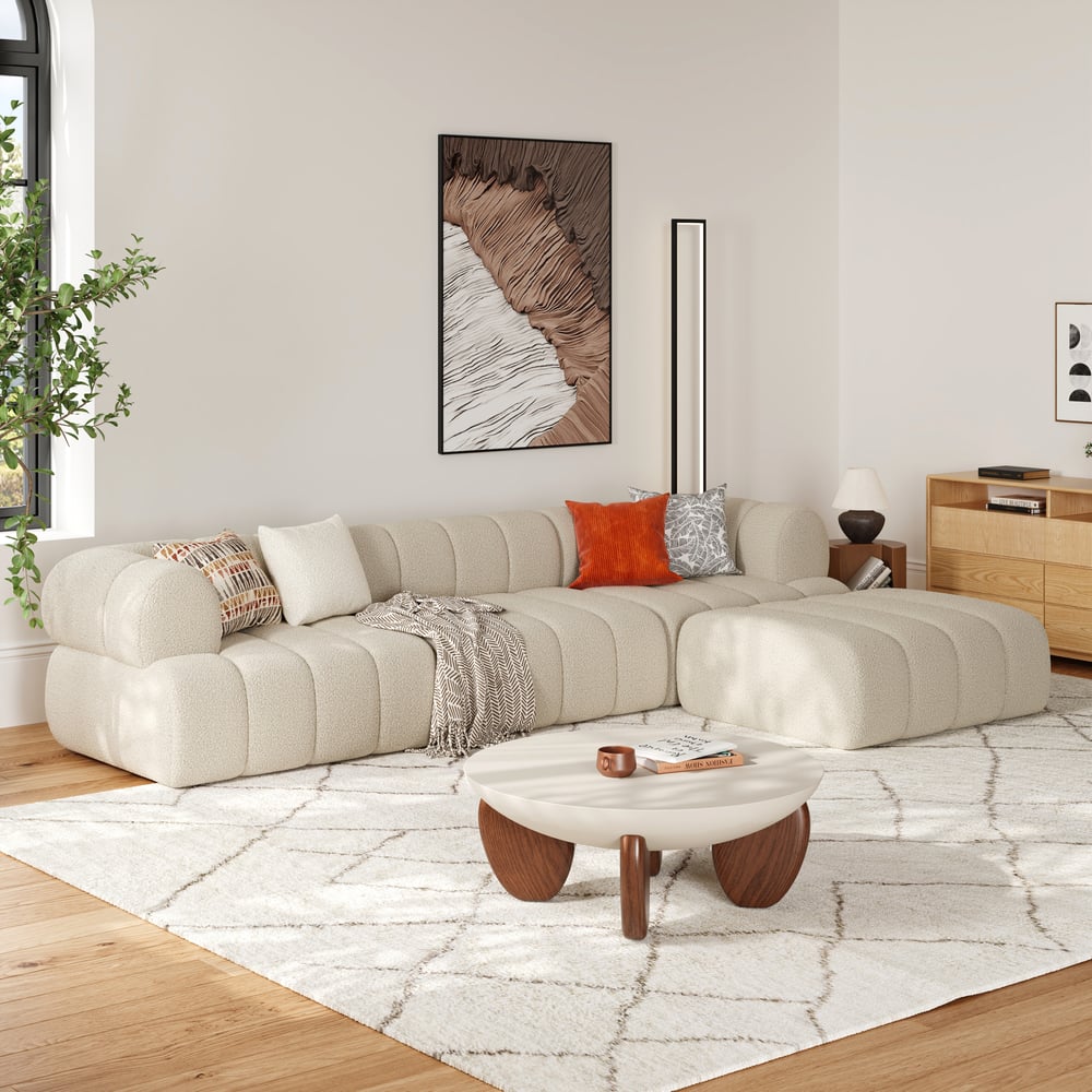 Modern living room with a beige sectional sofa, wooden coffee table, and decorative elements.