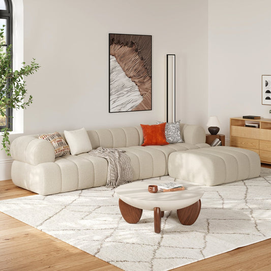 Modern living room with a beige sectional sofa, wooden coffee table, and decorative elements.