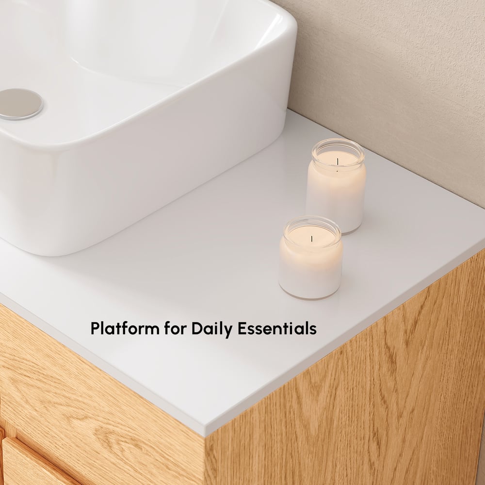 White countertop with two candles and a white sink in a bathroom setting.