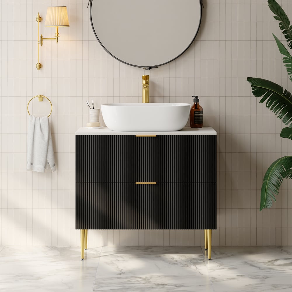 Bathroom vanity with black cabinet, white sink, and gold fixtures.