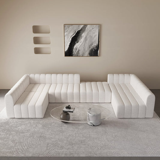 Modern white sectional sofa in a minimalistic living room with abstract art on the wall.