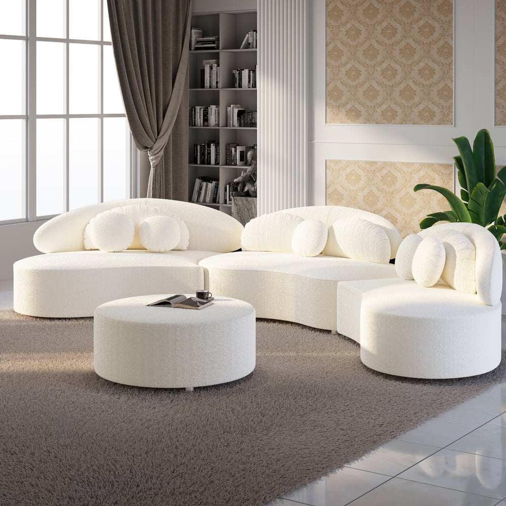 Modern white sofa set in a stylish living room with bookshelf and decor.