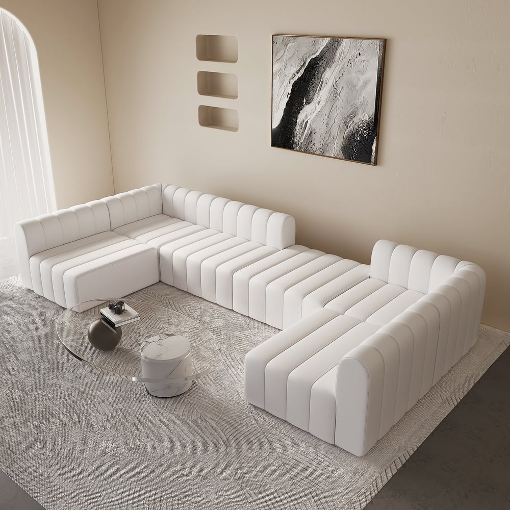 Modern white sofa in a stylish living room with abstract art on the wall.