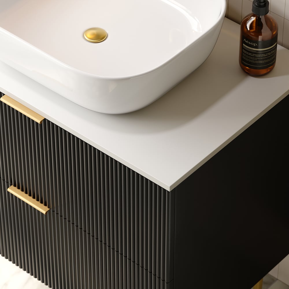 Bathroom vanity with white sink, black drawers, and gold handles.