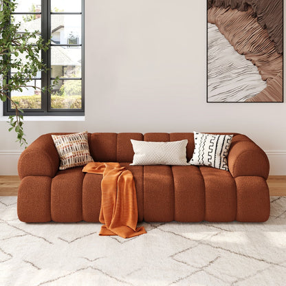 Brown sofa with decorative pillows and a blanket in a living room setting.