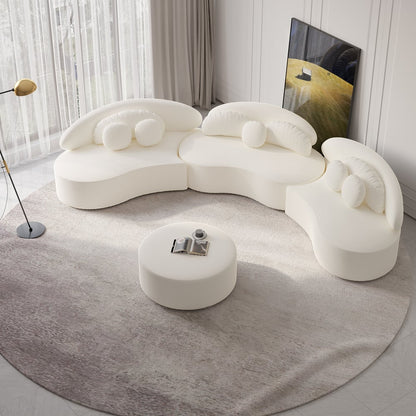 Modern white sofa with a round ottoman on a gray rug in a room with curtains and a painting.